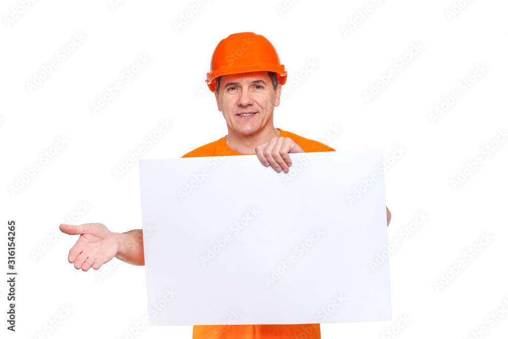 White smiling middle-aged handsome worker wearing orange hard hat, holding blank paper sheet in hand White smiling middle-aged handsome worker wearing orange hard hat, holding blank paper sheet in hand