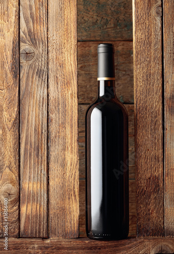 Bottle of red wine on a old wooden background.