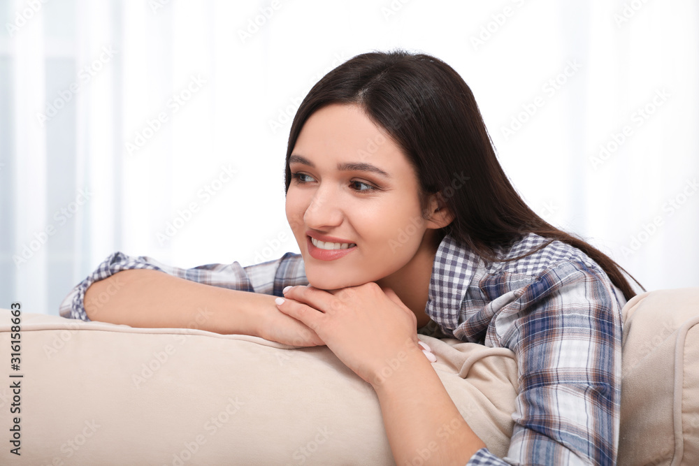 Young woman relaxing on couch at home Young woman relaxing on couch at home