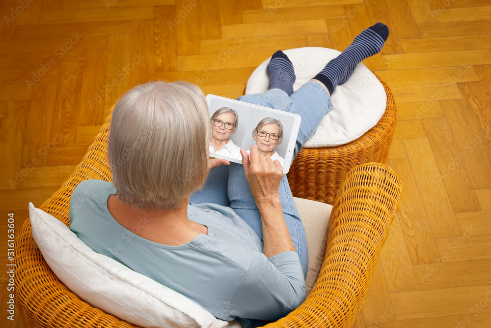 Φωτογραφία Shopping eyeglasses online concept: senior woman choosing her new glasses at home in her living room