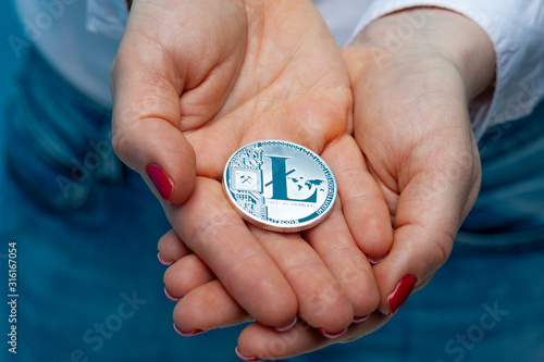 An unidentified young woman holds a litecoin