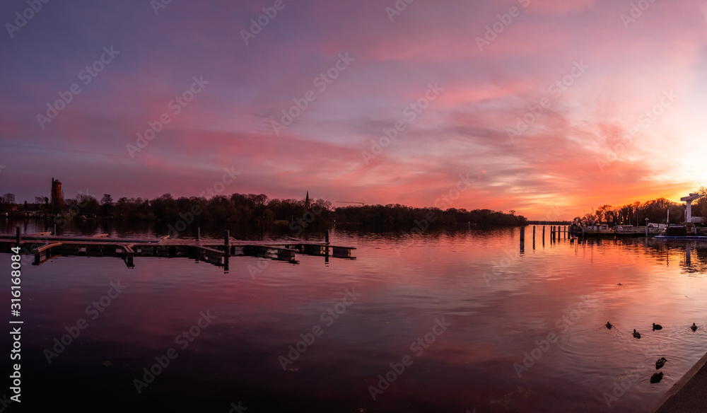 Fototapeta premium Reflection on a lake during colorful sunset, stock image, Potsdam, Germany