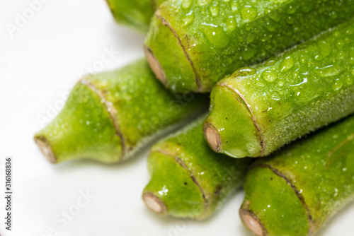 Fresh green okra or lady fingers. Close up macro shot with water droplets. 