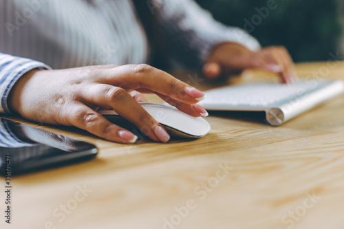 Side-view of usiness person hands using touchpad and computer mouse.