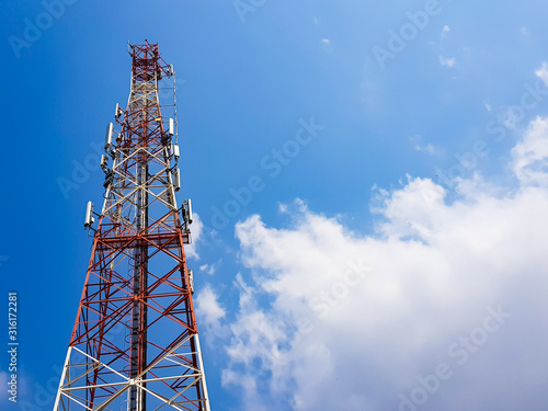 Ground shot of Mobile phone antenna with white cloud and clear blue sky background. Wireless network technology for voice and high speed 4g,5g data usage connection. Base station to boost signal.