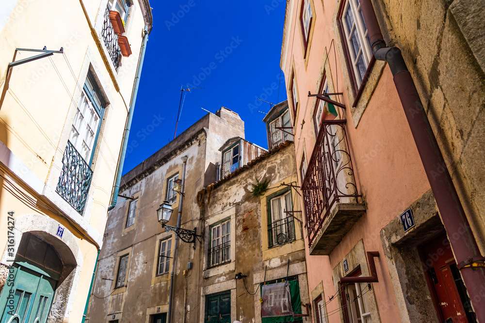 Narrow alley of Lisbon on a summer day with blue sky