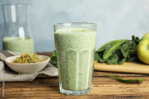 Tasty green buckwheat smoothie on wooden table