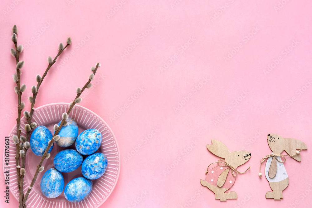 Easter greeting card with blue easter eggs and easter bunny on pink pastel background. Top view with space for your text.