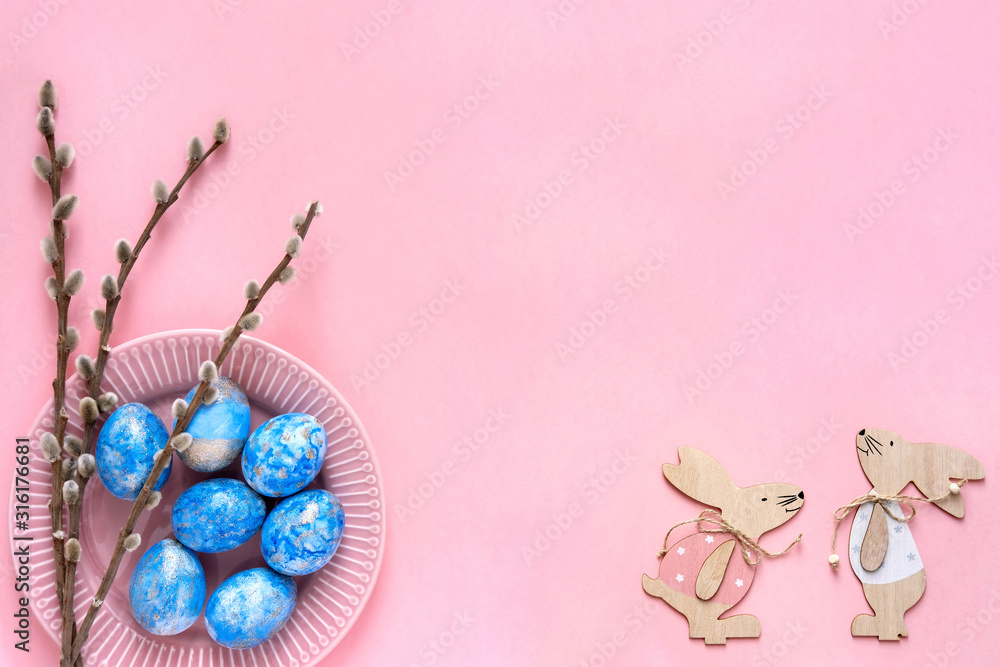 Naklejka premium Easter greeting card with blue easter eggs and easter bunny on pink pastel background. Top view with space for your text.