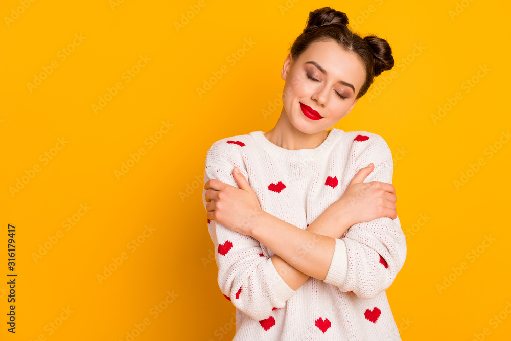 Photo of beautiful lady hugging herself shoulders eyes closed enjoy pullover softness wear hearts pattern white red knitted sweater isolated yellow color background - obrazy, fototapety, plakaty 