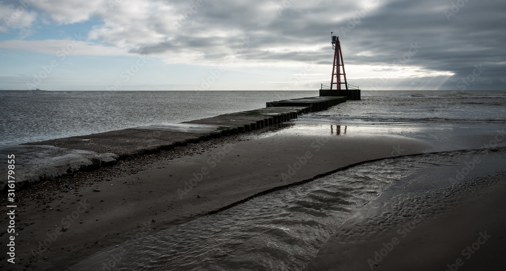 Fototapeta premium Harbour light at low tide, Rye Harbour, Sussex, England