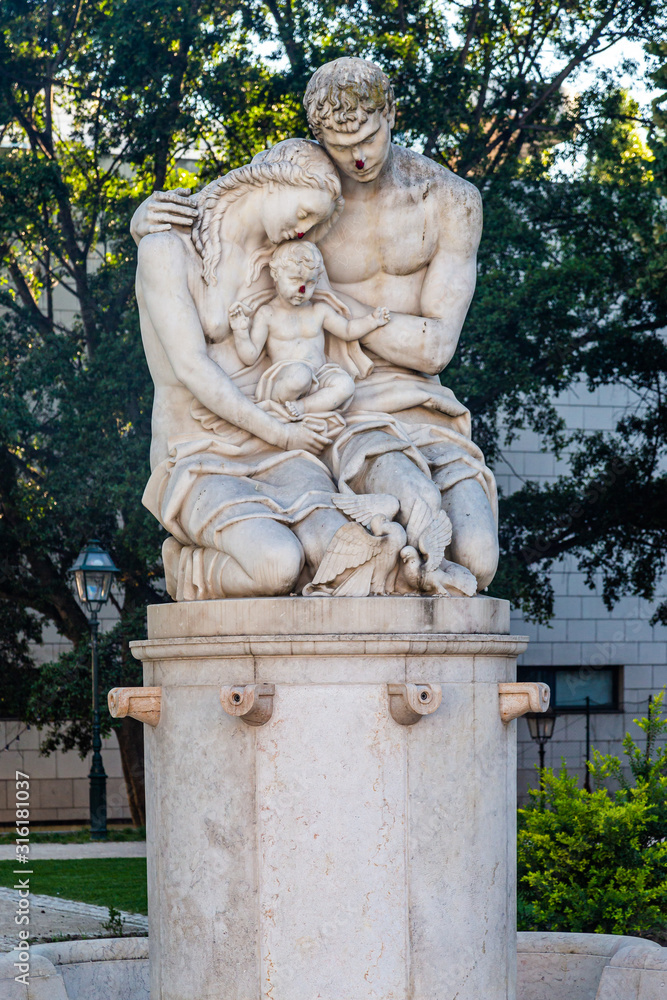 Statue of a mother a father and a child in a public garden in Lisbon, Portugal