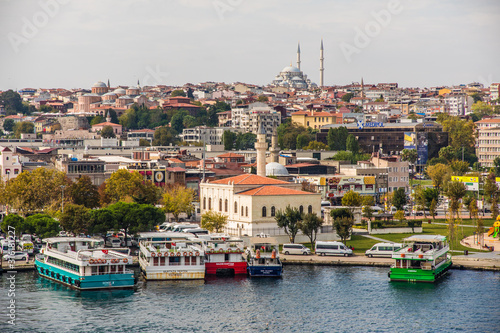  Tourist ship sails on the Golden Horn, Istanbul, Turkey. Scenic sunny panorama of Istanbul city in summer. Beautiful waterfront of Istanbul at sunset. Concept of traveling and vacation in Istanbul.