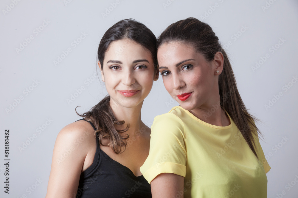 ritartto di due amiche spalla su spalla sorridono - sfondo chiaro ritartto di due amiche spalla su spalla sorridono - sfondo chiaro