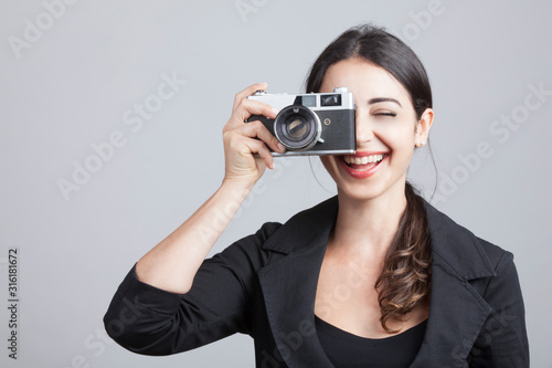 giovane fotografa , usa la sua reflex - isolata su sfondo neutro