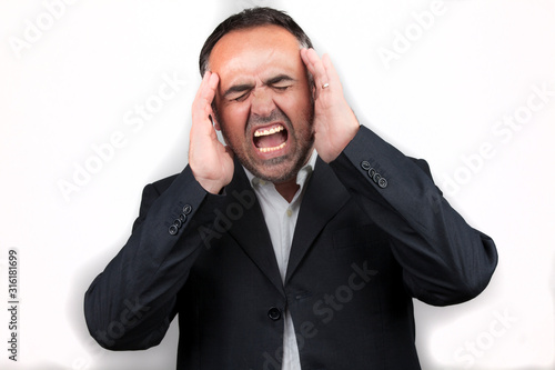uomo mediterraneo si tocca le tempie a causa di un forte mal di testa - sfondo bianco photo