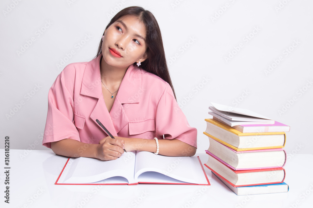 Young Asian woman read a book with books on table. Young Asian woman read a book with books on table.