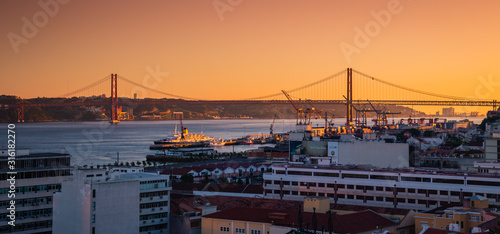 25 de abril bridge and the Tagus river at sunset in Lisbon with a view on the harbor of the city