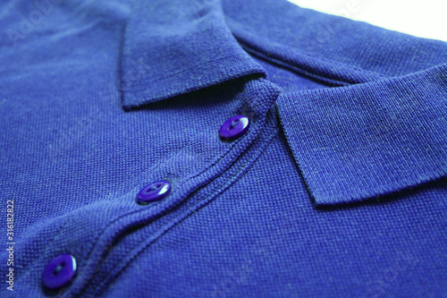 Blue polo shirt close up view of casual buttoned cotton top. Minimalist polo shirt design, simple short sleeve tee front. Men and women stylish blue top, low angle view 