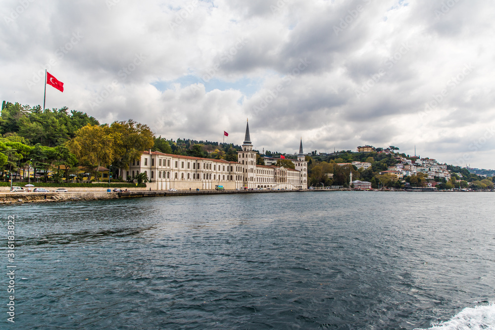 Fototapeta premium Tourist ship sails on the Golden Horn, Istanbul, Turkey. Scenic sunny panorama of Istanbul city in summer. Beautiful waterfront of Istanbul at sunset. Concept of traveling and vacation in Istanbul.