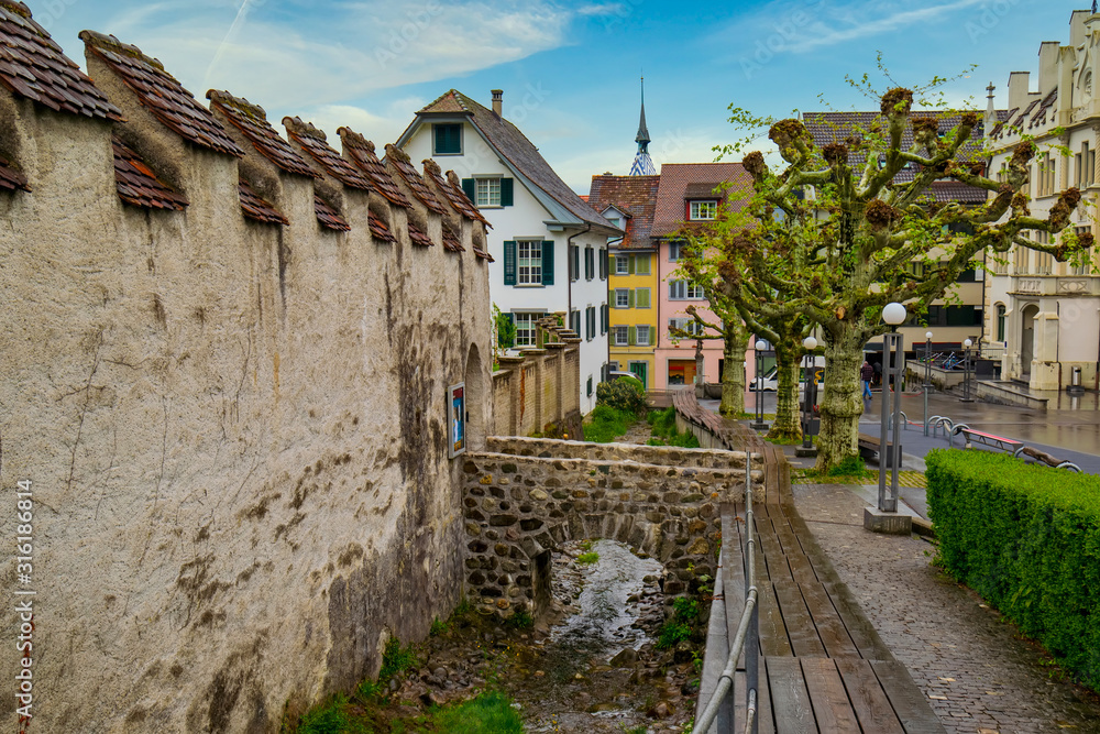 Old street in Zug City along defence wall and water duct of Burg Zug, Switzerland