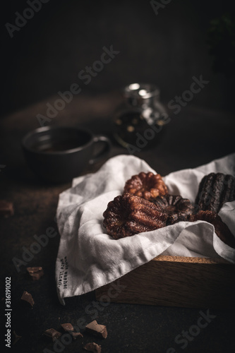 Canneles desserts in wooden box dark and moody food photography
