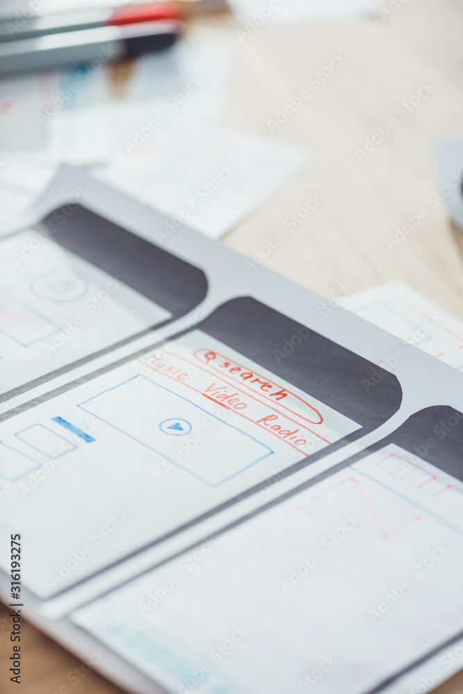 Fototapeta premium Selective focus of ui planning for mobile app on wooden table