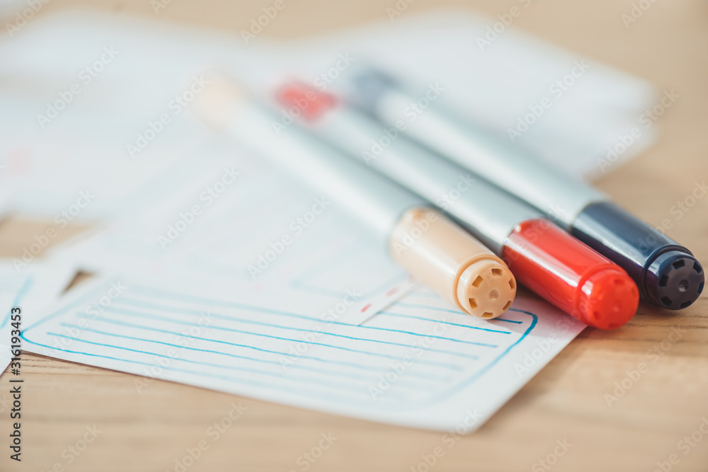 Selective focus of pens on user experience design sketches on wooden table Selective focus of pens on user experience design sketches on wooden table