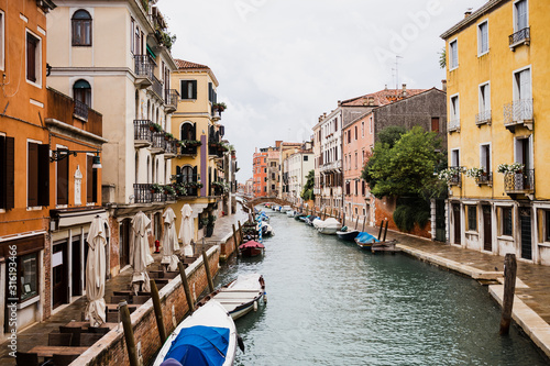 motor boats near ancient and bright buildings in Venice, Italy