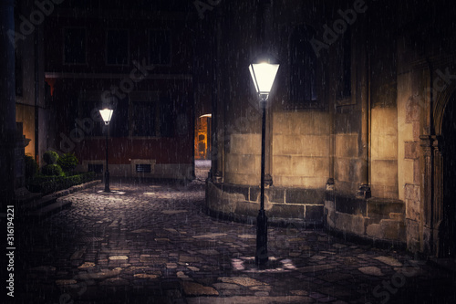Rainy night in old European city with lanterns