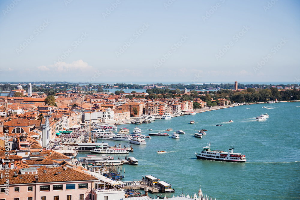 view of ancient buildings, motor boats and vaporettos floating on river in Venice, Italy