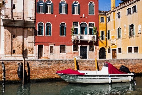 motor boat near bright and colorful buildings in Venice, Italy