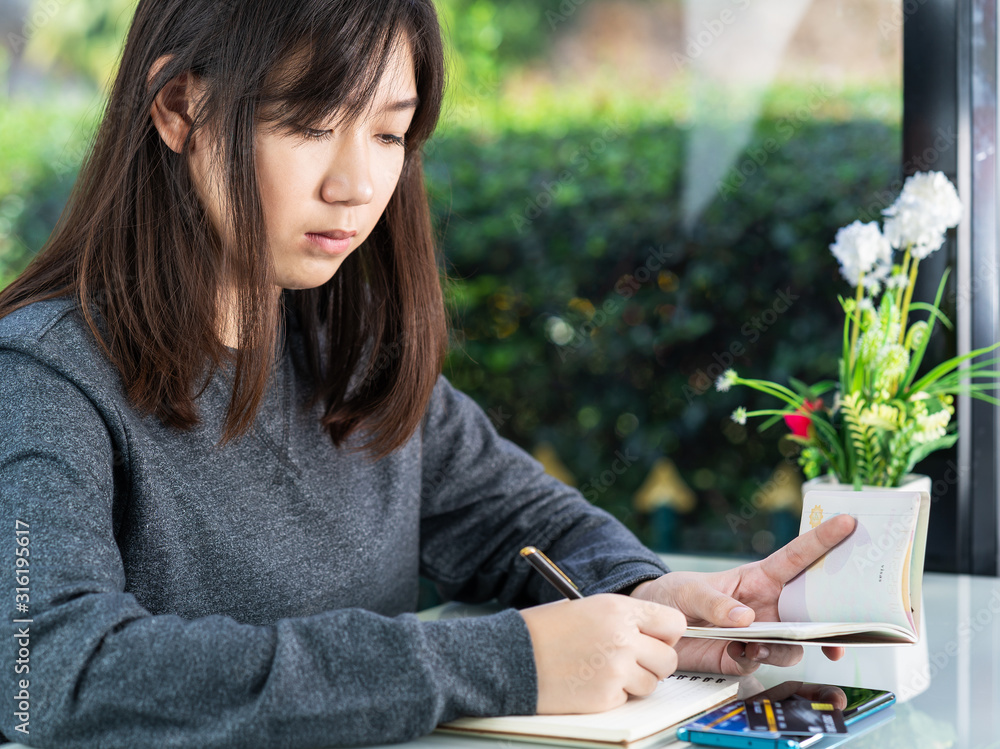 Obraz premium Young woman sitting holding passport and credit card