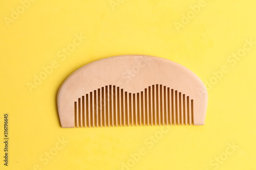 wooden comb in color background photo