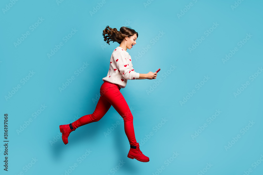 Full length body size view of her she nice attractive cheerful cheery glad girl jumping using device running hurry rush spending free time isolated on bright vivid shine vibrant blue color background