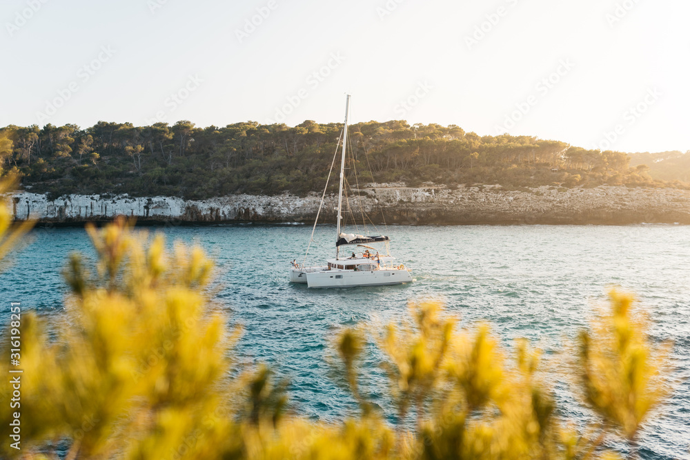 Beautiful Bay with Sailing Boat Catamaran at Sunset on the Isle of Mallorca