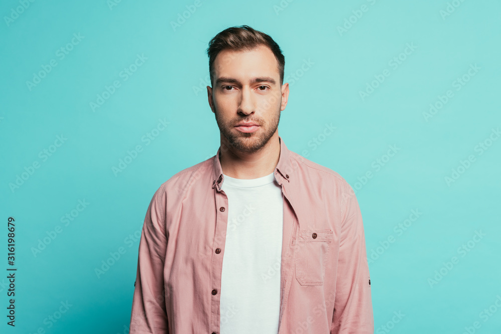 upset handsome man standing isolated on blue upset handsome man standing isolated on blue