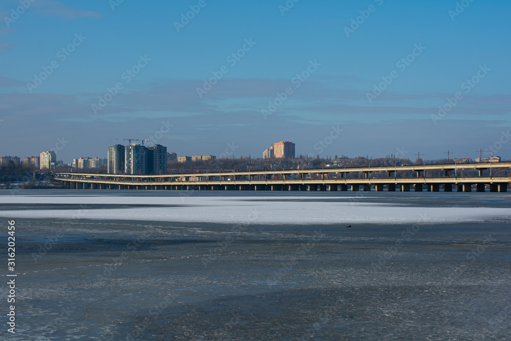 Two-level bridge over the winter river with ice