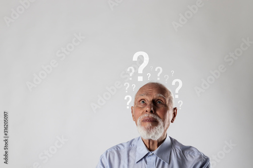 Old man and question marks. Dementia and ignorance. Confused old man.
