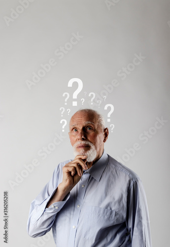 Old man and question marks. Confused old man.