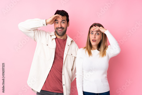 Couple in Valentine Day over isolated pink background has just realized something and has intending the solution