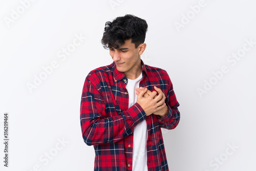 Young Argentinian man over isolated white background having a pain in the heart