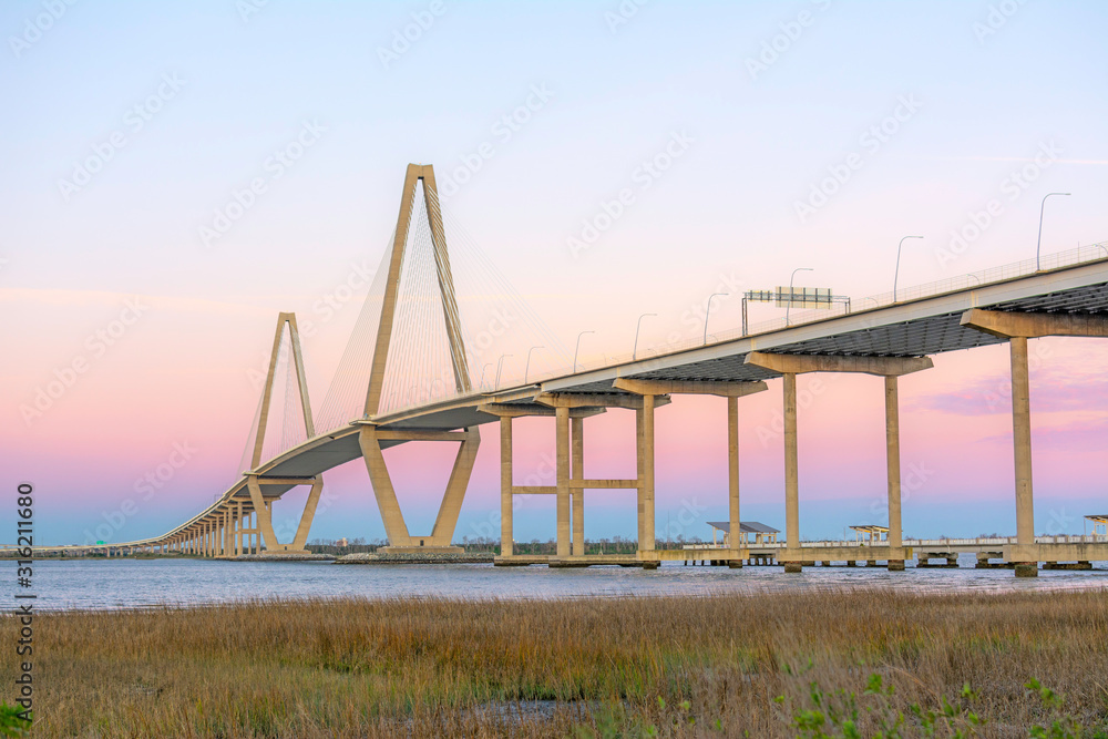 Naklejka premium Most Arthur Ravenel Jr., znany również jako Cooper River Bridge, został otwarty w 2005 r. Most wantowy, który łączy Charleston z Mount Pleasant, Karolina Południowa, obsługuje ruch na autostradzie US-17. Zdjęcie w porannej złotej godzinie.