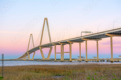 The Arthur Ravenel Jr. Bridge, aka Cooper River Bridge, opened in 2005. A cable-stayed bridge, it connects Charleston to Mount Pleasant, SC, carries traffic on US-17. Photo during morning golden hour.