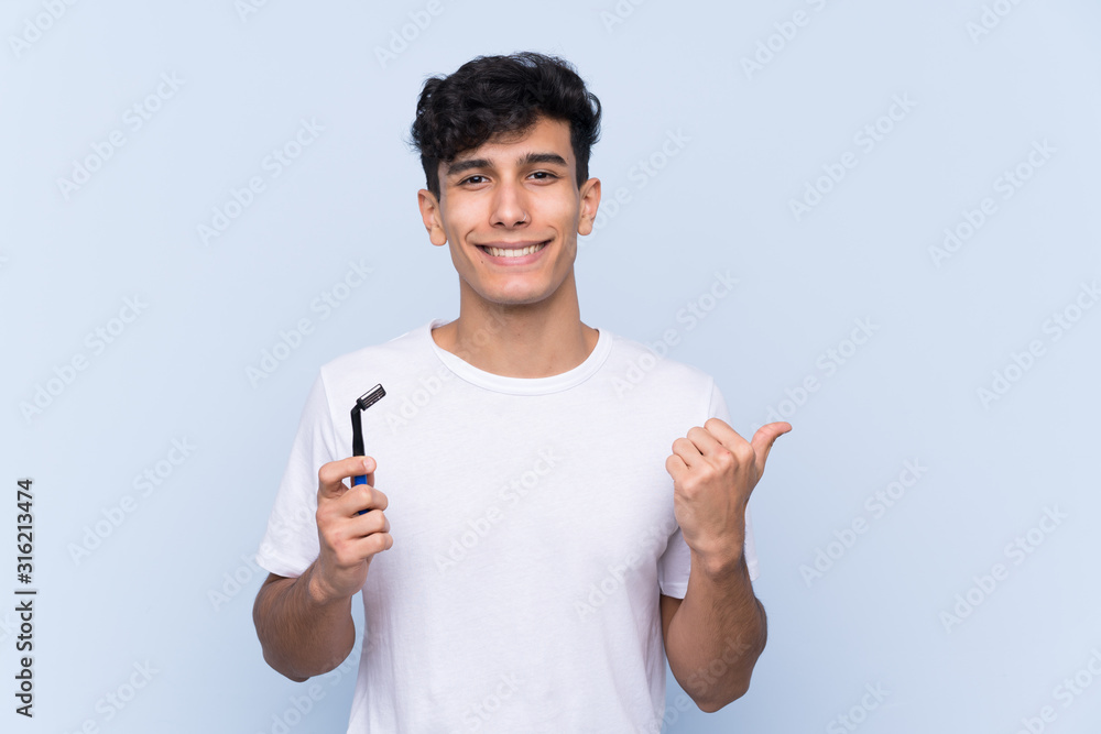 Man shaving his beard over isolated white background pointing to the side to present a product Man shaving his beard over isolated white background pointing to the side to present a product