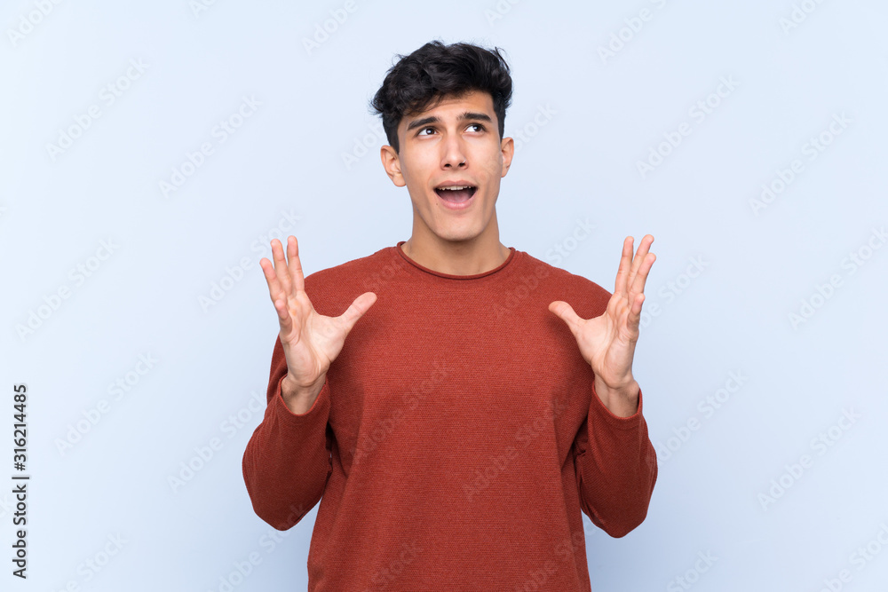 Young Argentinian man over isolated blue background frustrated by a bad situation Young Argentinian man over isolated blue background frustrated by a bad situation