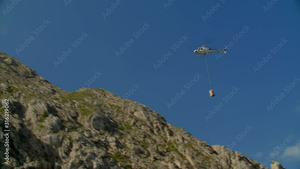 Helicopter AS350 flight carrying cargo on hook Helicopter AS350 flight carrying cargo on hook