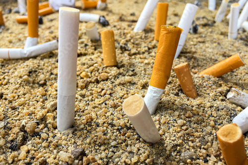 Close up of cigarette filters in sand tray. The sand was littered with fag ends.