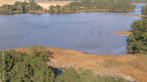 Aerial footage sliding from right to left while slowly panning up while looking down a country river. photo