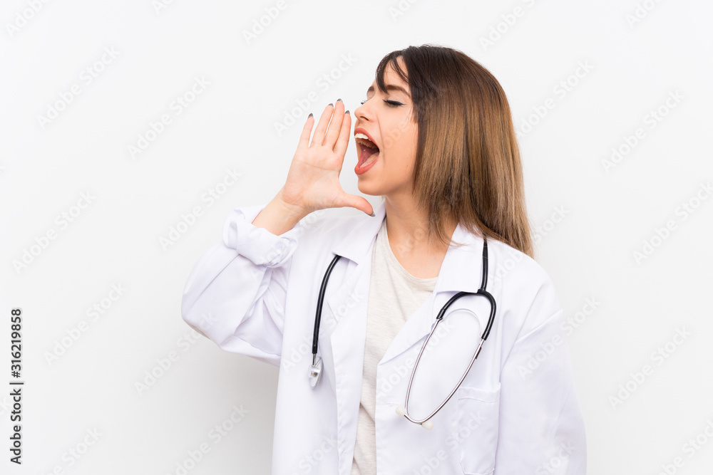 Young doctor woman over isolated background shouting with mouth wide open Young doctor woman over isolated background shouting with mouth wide open
